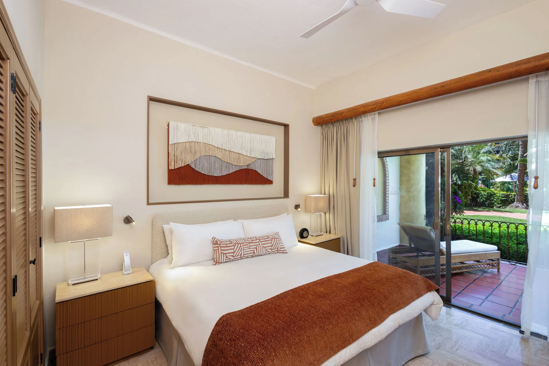 Deluxe Suite bedroom with king bed and terrace doors at Velas Vallarta Suites Resort.