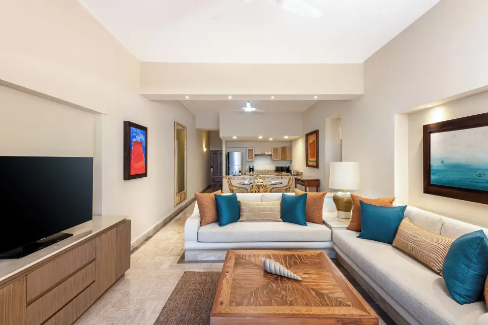 Deluxe Suite living room with sofas and kitchenette at Velas Vallarta Suites Resort.