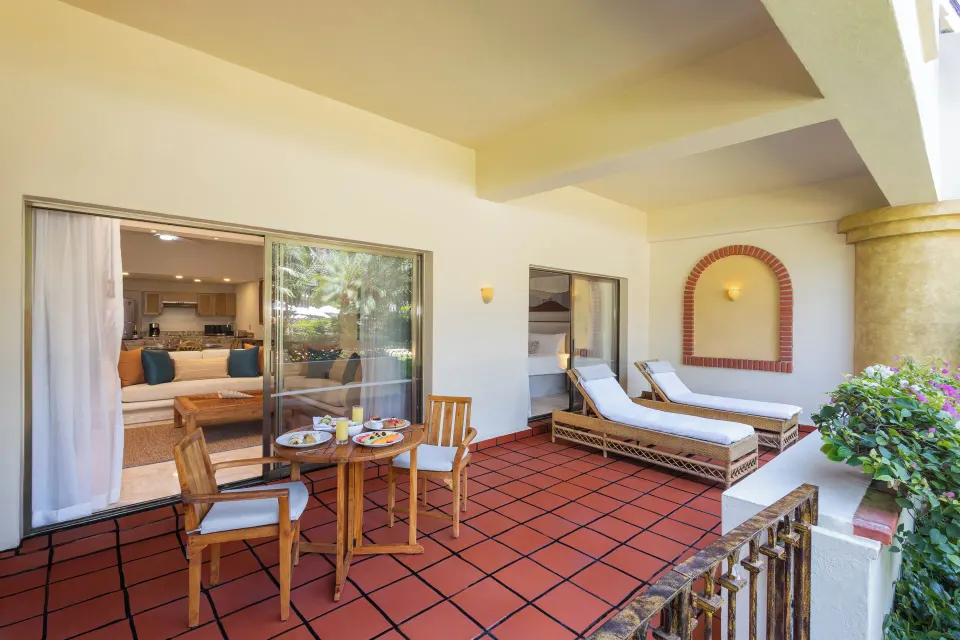 Deluxe Suite terrace with loungers and dining table at Velas Vallarta Suites Resort.