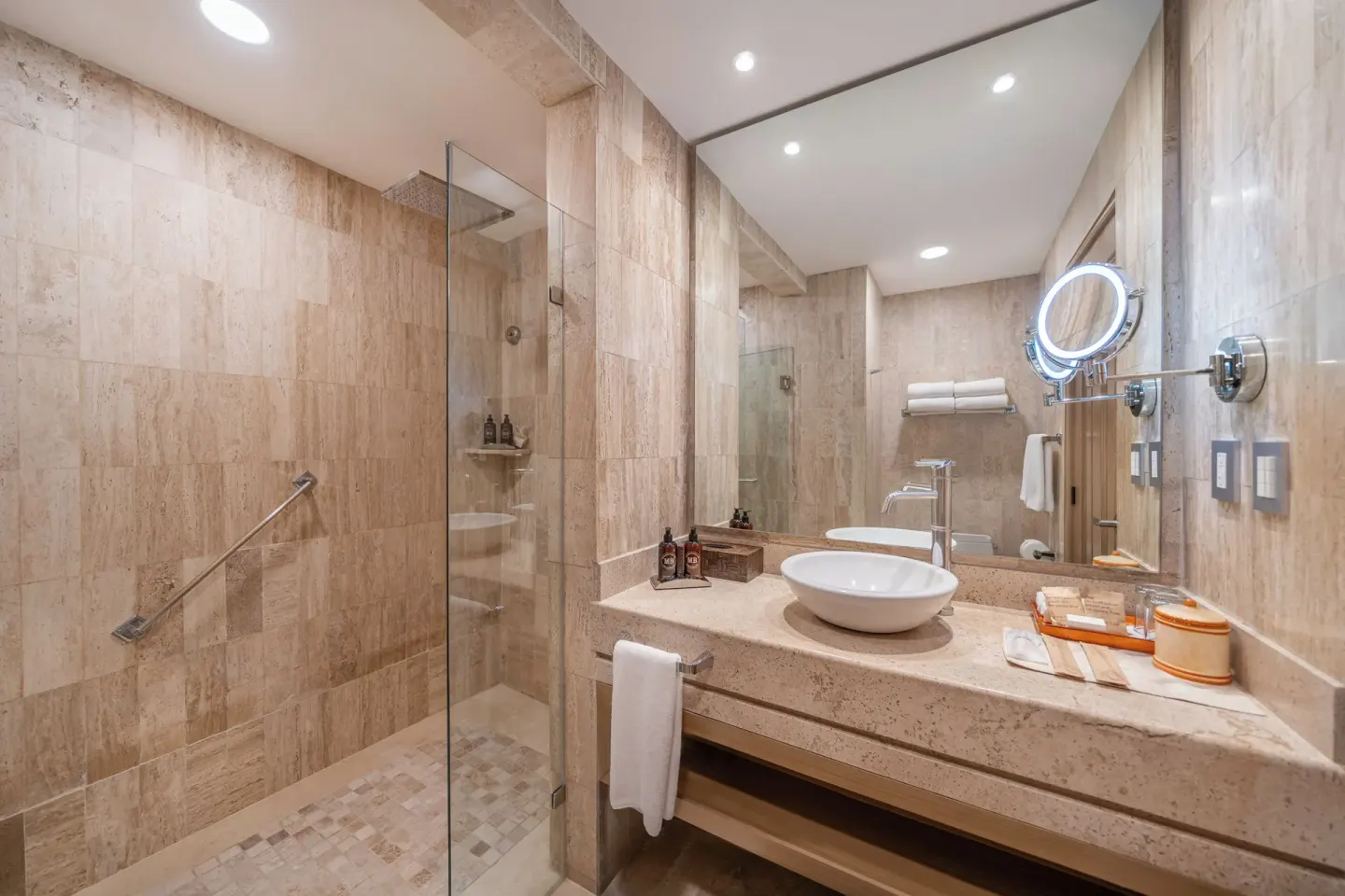 Family Suite bathroom at Velas Vallarta Suites Resort with vessel sink, mirror, and glass shower.