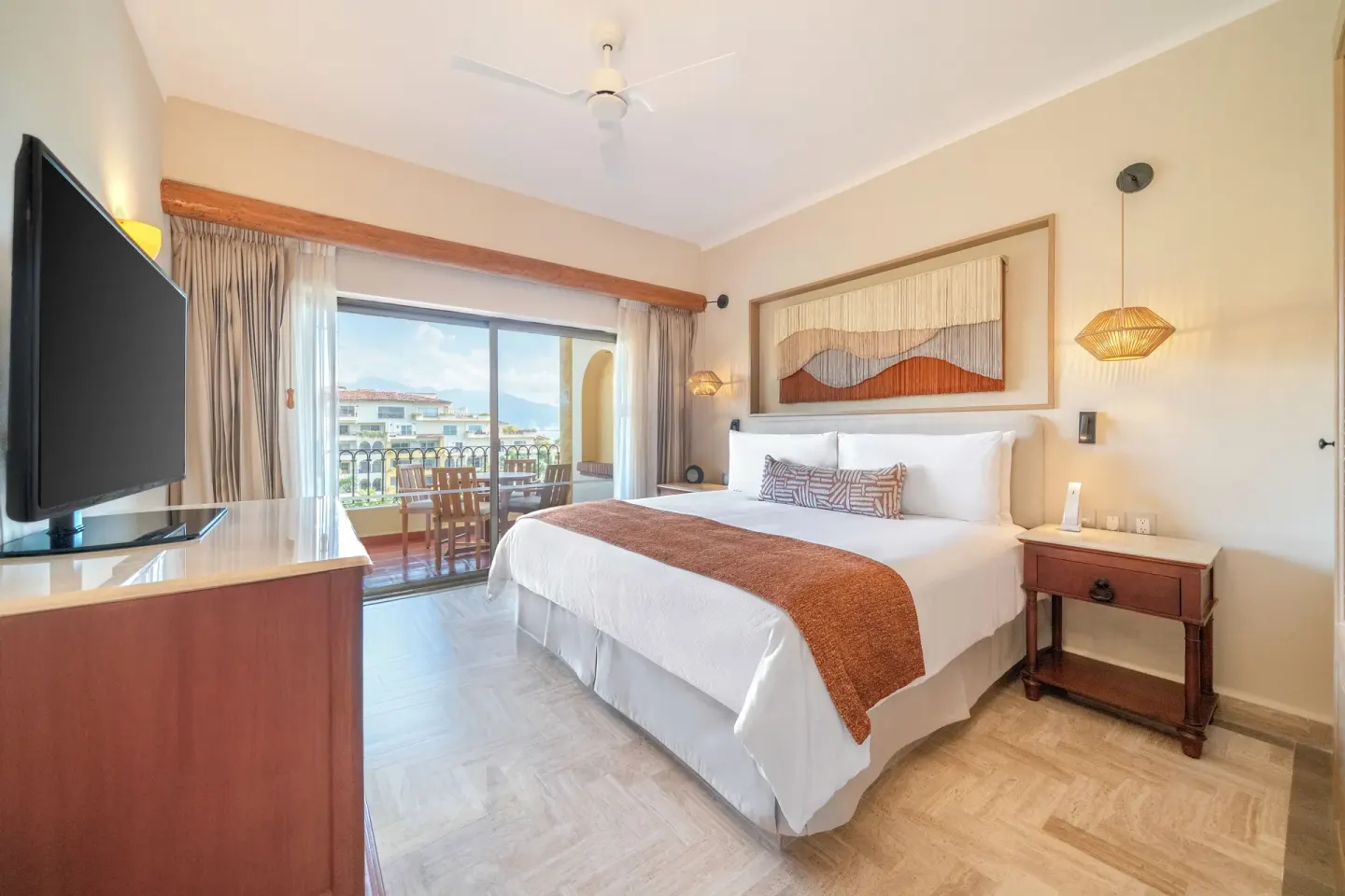 Family Suite king bedroom at Velas Vallarta Suites Resort with balcony doors and ocean-facing view.