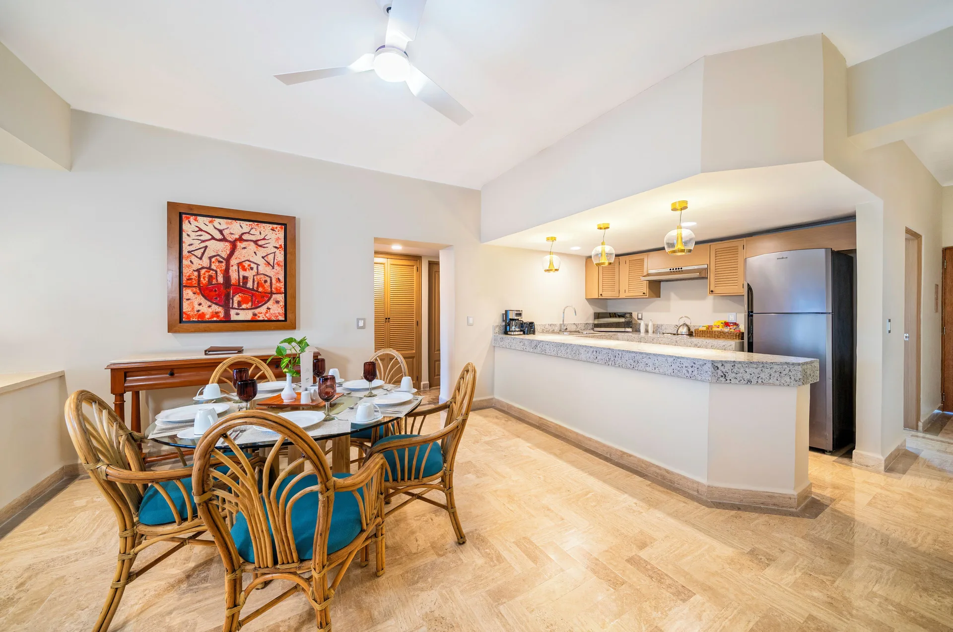 Suite dining area and kitchen with table and breakfast bar at Velas Vallarta Suites Resort.