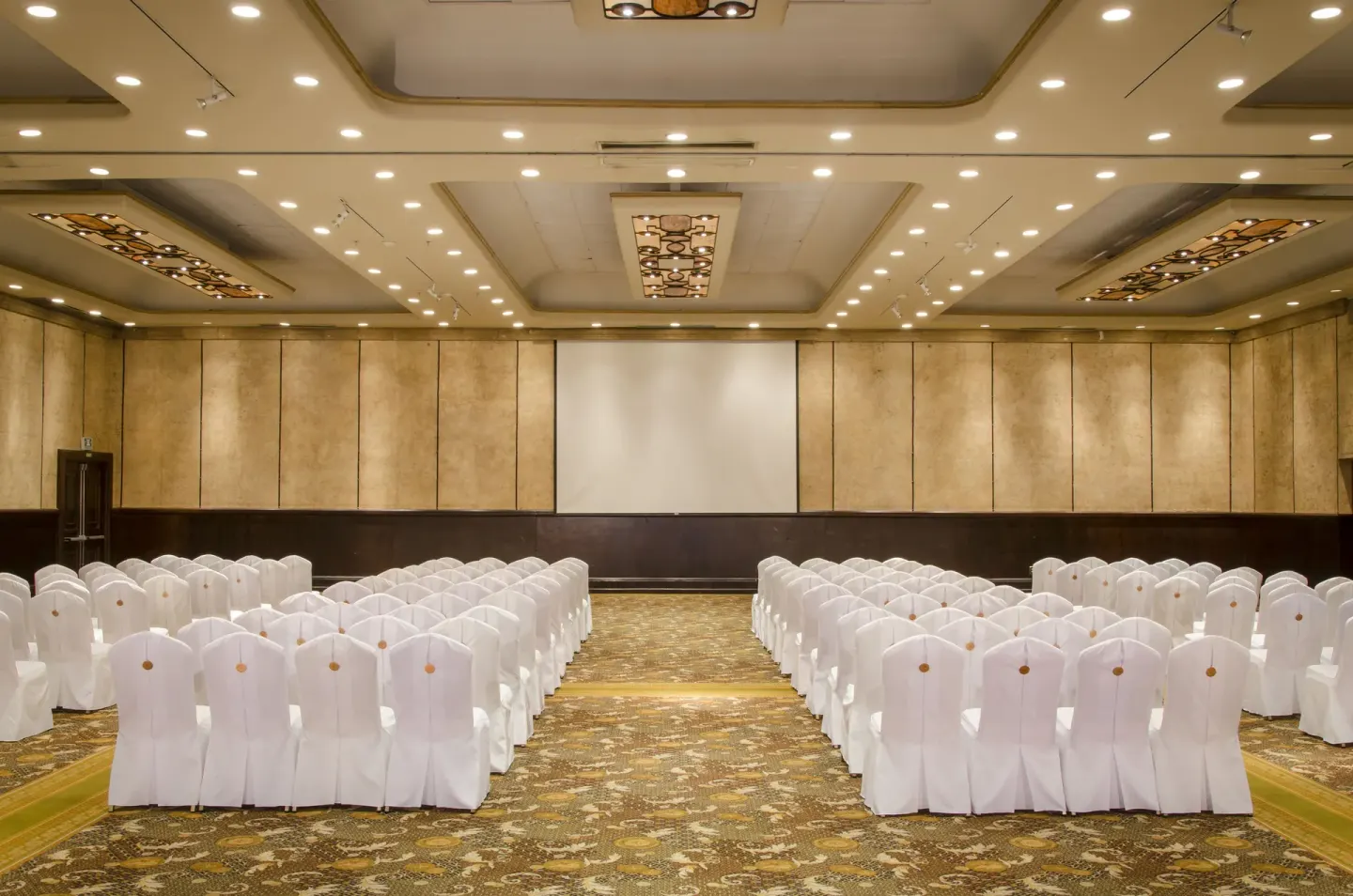 Theater-style ballroom seating facing a projection screen at Velas Vallarta Suites Resort.