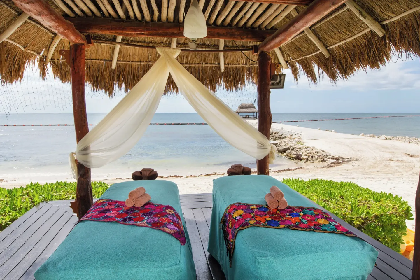 Beachfront massage palapa with two treatment beds at Ventus at Marina El Cid Spa & Beach Resort.