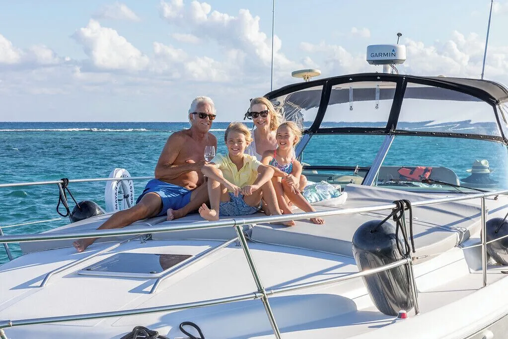 Family relaxing on a boat over turquoise water near Ventus at Marina El Cid Spa & Beach Resort.
