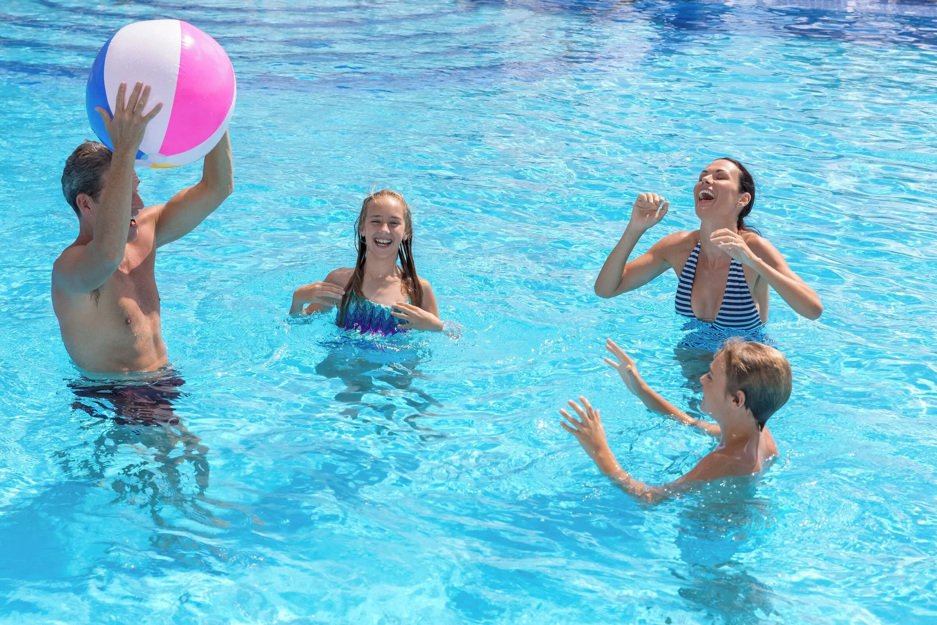 Family plays with a beach ball in the pool at Ventus at Marina El Cid Spa & Beach Resort.