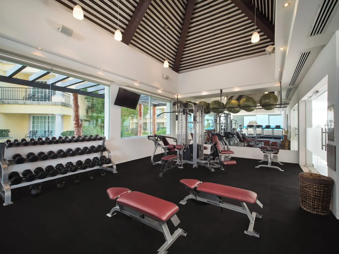 Weight benches and free weights fill the fitness room at Ventus at Marina El Cid Spa & Beach Resort.