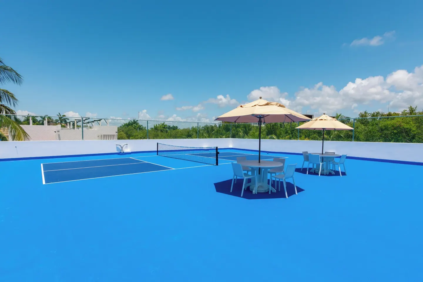 Empty blue pickleball court with umbrellas at Ventus at Marina El Cid Spa & Beach Resort.