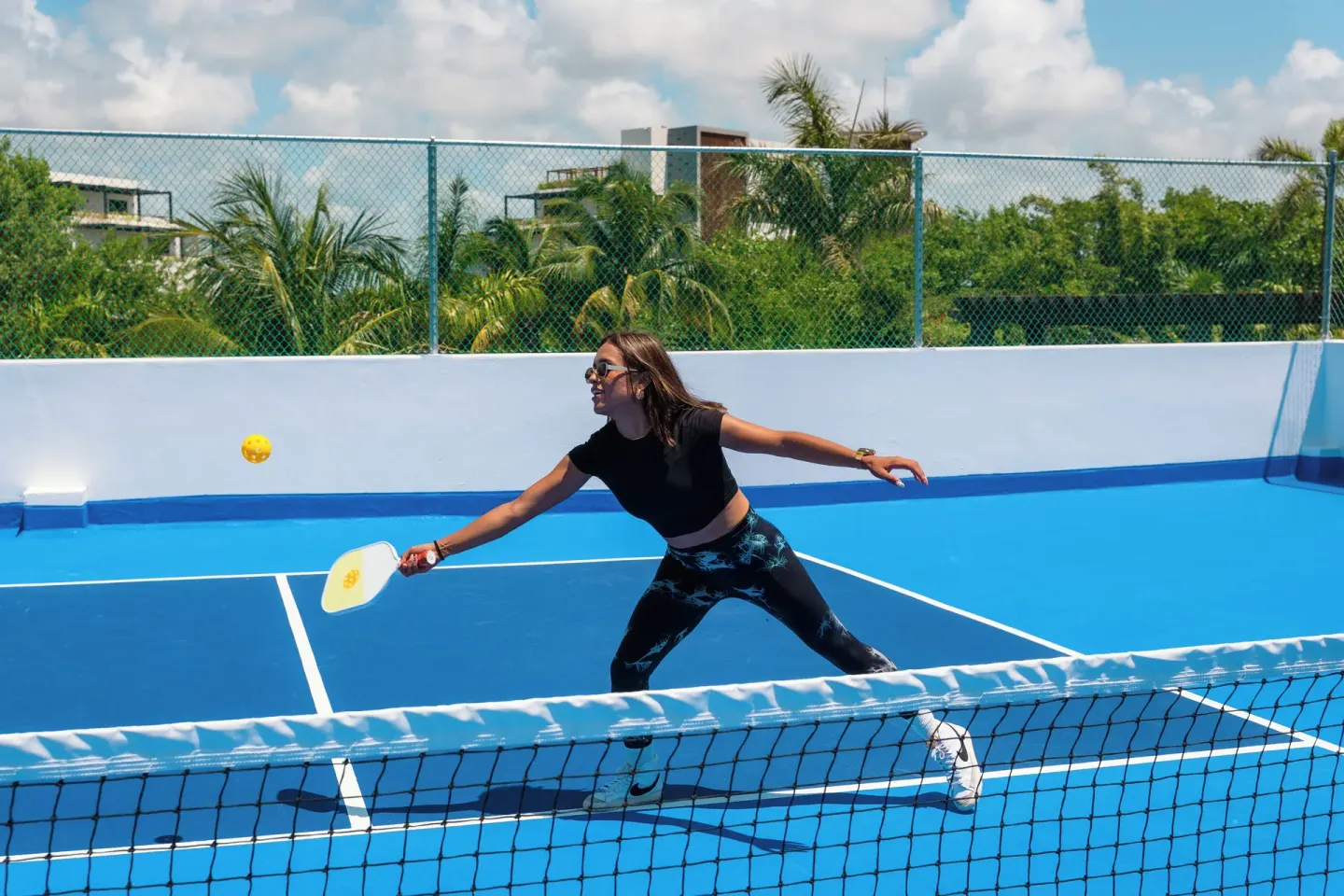 Guest playing pickleball on a blue court at Ventus at Marina El Cid Spa & Beach Resort.