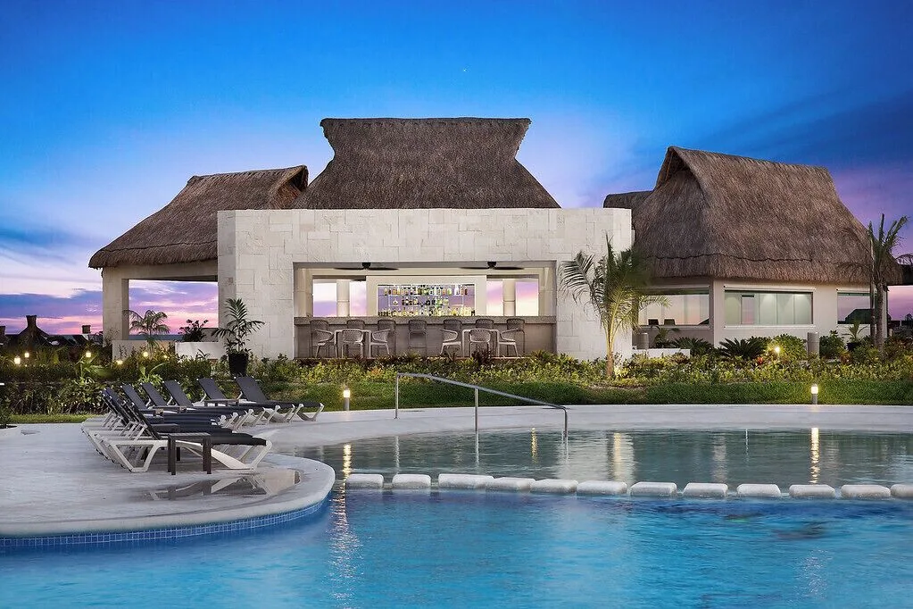 Thatched poolside bar pavilion at dusk at Ventus at Marina El Cid Spa & Beach Resort.