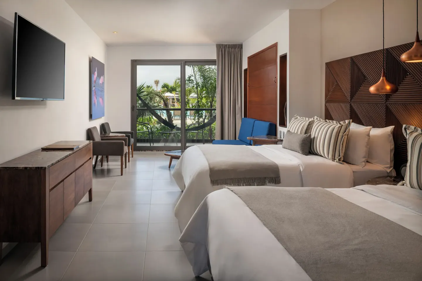 Family Room with two beds and tropical balcony view at Ventus at Marina El Cid Spa & Beach Resort.