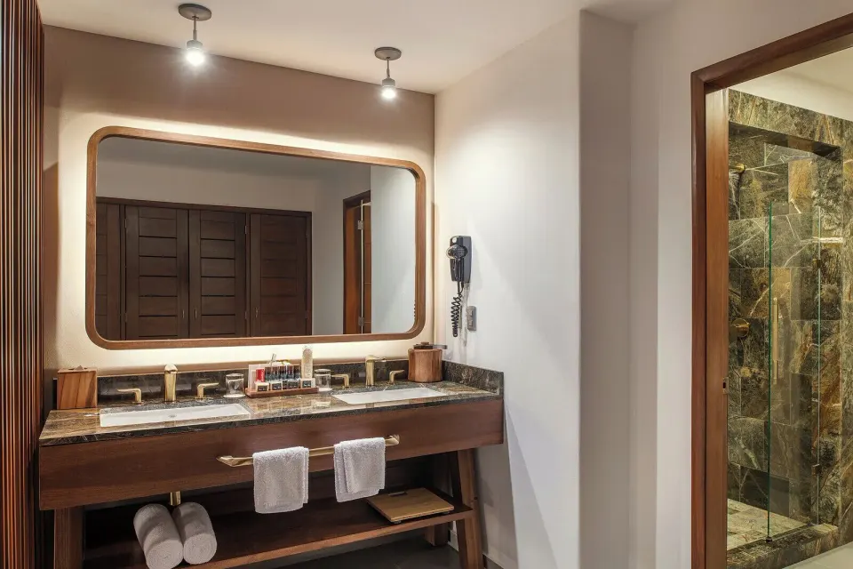 Junior Suite bathroom vanity and shower at Ventus at Marina El Cid Spa & Beach Resort.
