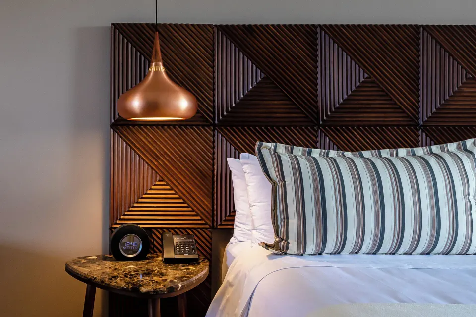 Junior Suite king bed detail with side table at Ventus at Marina El Cid Spa & Beach Resort.