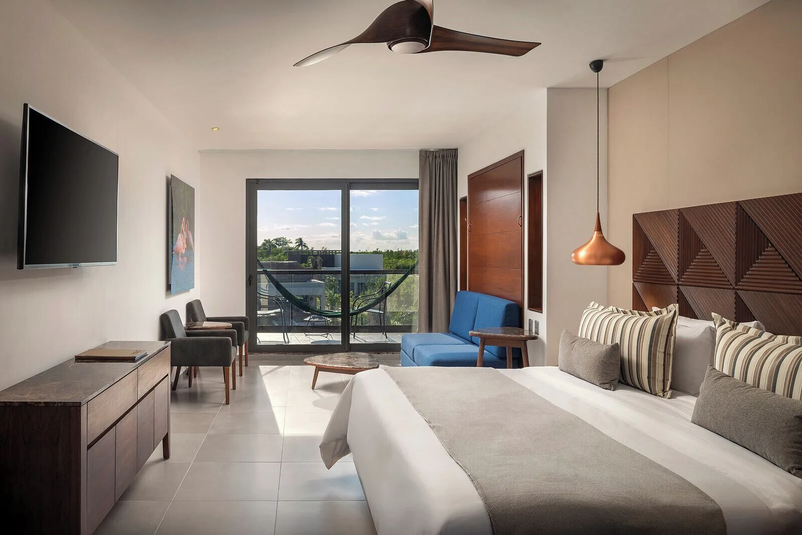Junior Suite king bed and sitting area at Ventus at Marina El Cid Spa & Beach Resort.