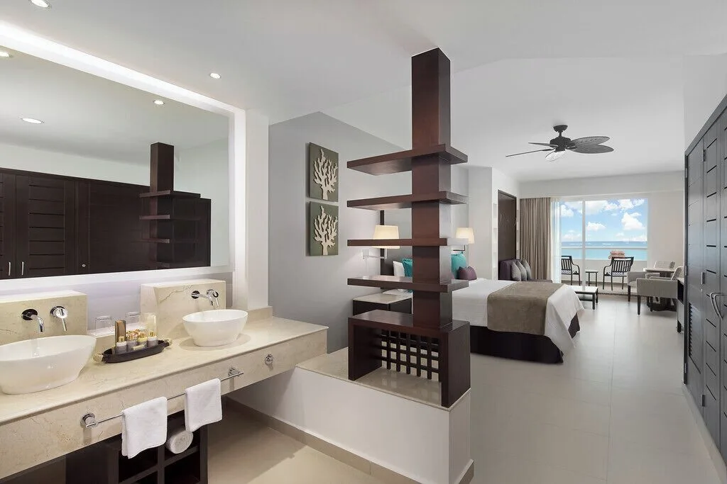Junior Suite Platinum with open vanity, king bed, and ocean-facing balcony at Ventus at Marina El Cid Spa & Beach Resort.