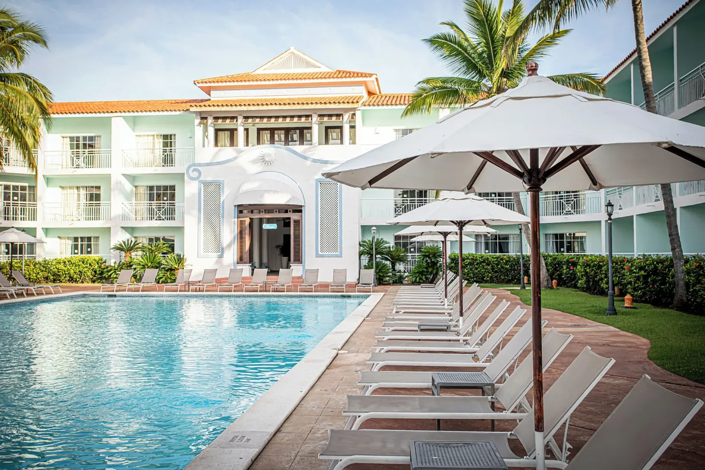 Poolside loungers and umbrellas beside the main building at VH Gran Ventana Beach Resort.
