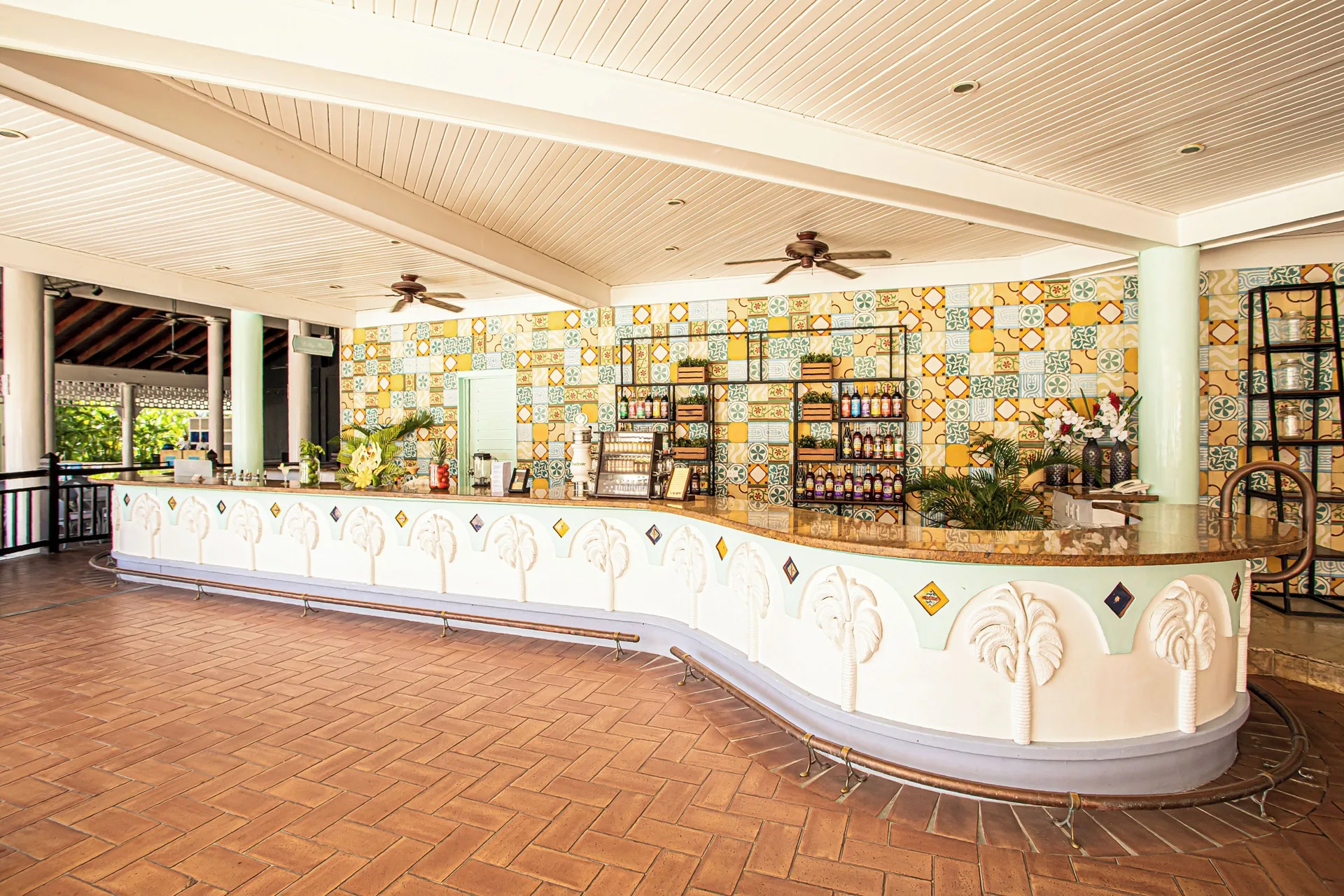 Open-air bar counter with tiled wall and palm details at VH Gran Ventana Beach Resort.