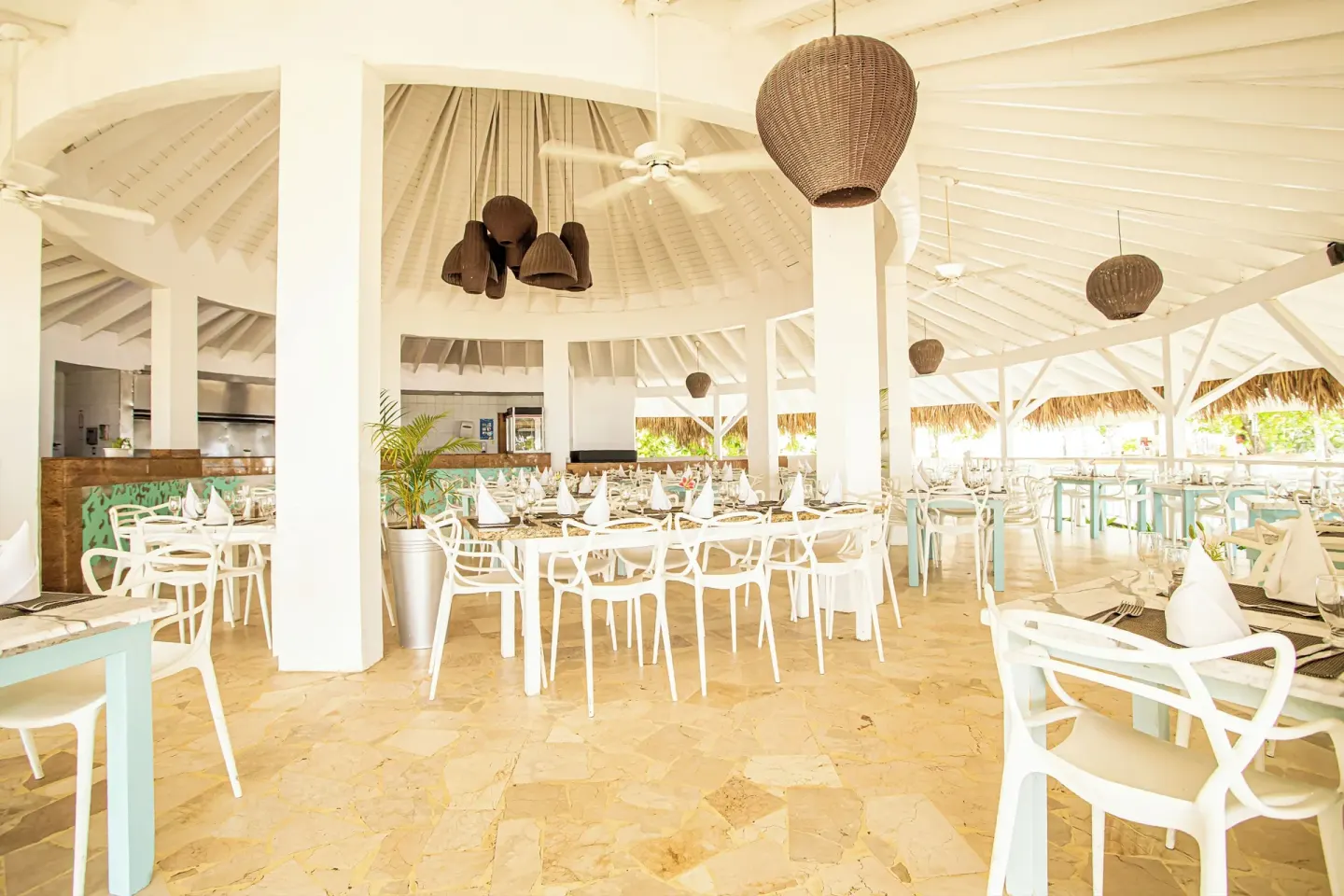 Open-air dining room with white chairs and set tables at VH Gran Ventana Beach Resort.