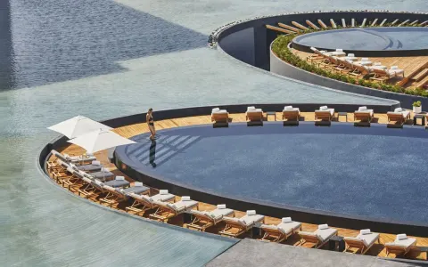 Circular pool decks with loungers surrounded by water at Viceroy Los Cabos.