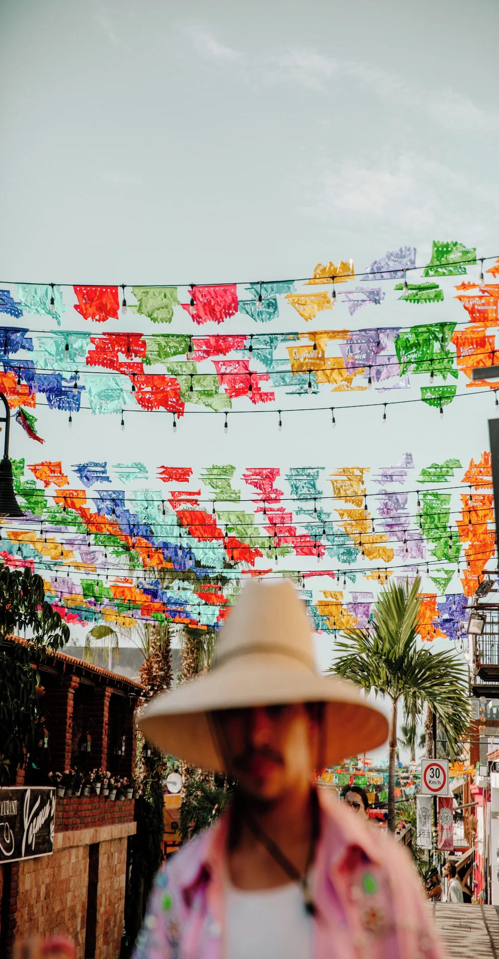 Colorful papel picado banners over a street scene near Viceroy Los Cabos.