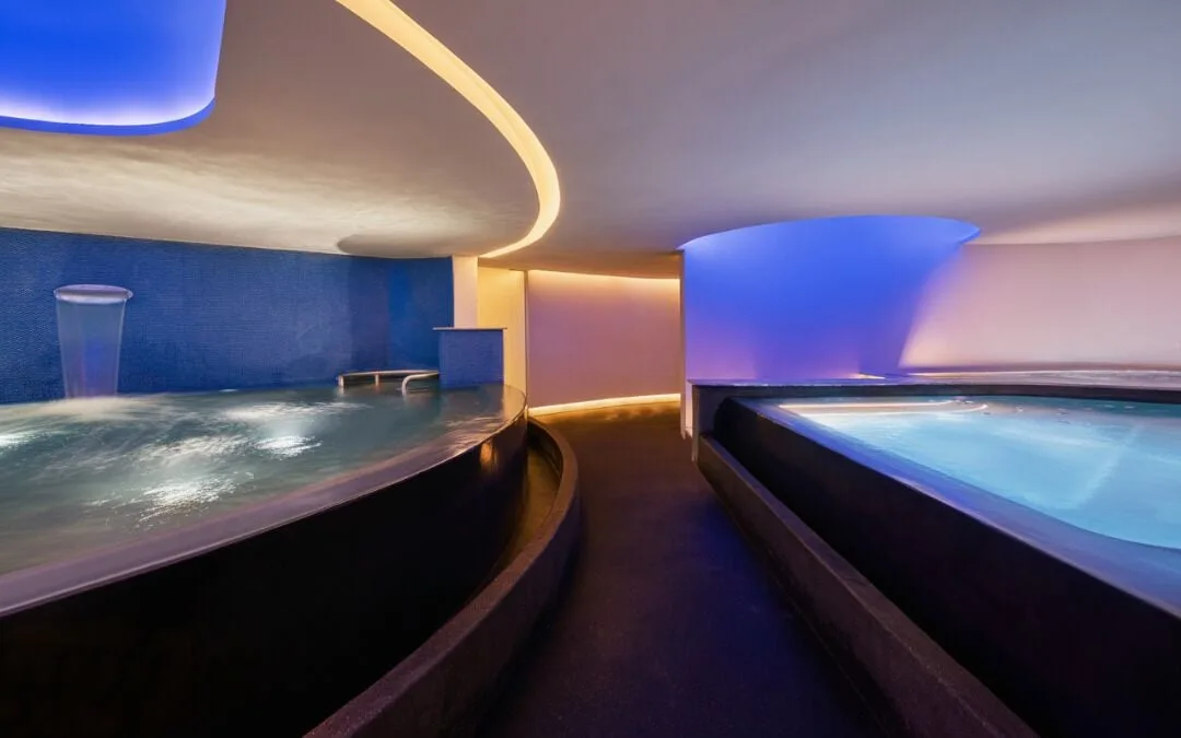 Curved indoor hydrotherapy pools glow with blue lighting at Viceroy Los Cabos.