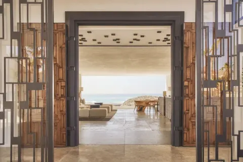 Open lobby doorway framing lounge seating and ocean view at Viceroy Los Cabos.