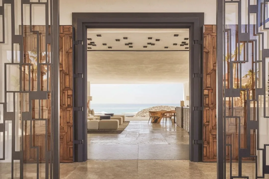 Open lobby doorway framing lounge seating and ocean view at Viceroy Los Cabos.