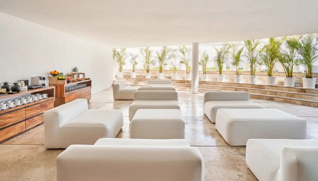 White lounge seating and breakfast buffet setup in a bright space at Viceroy Los Cabos.