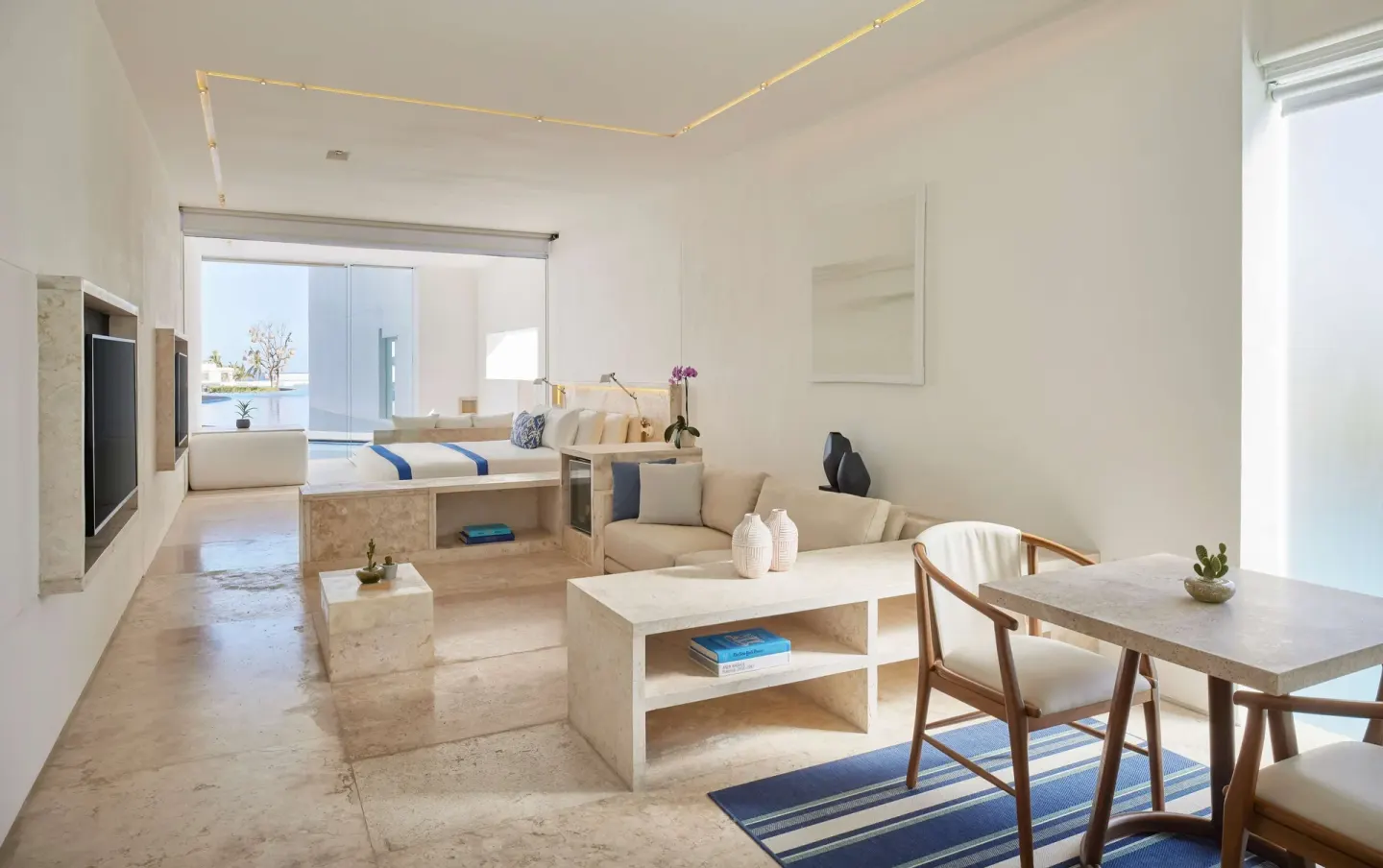 Open-plan guest room with bed, sofa and dining area at Viceroy Los Cabos.