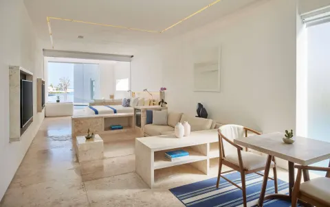 Open-plan guest room with bed, sofa and dining area at Viceroy Los Cabos.