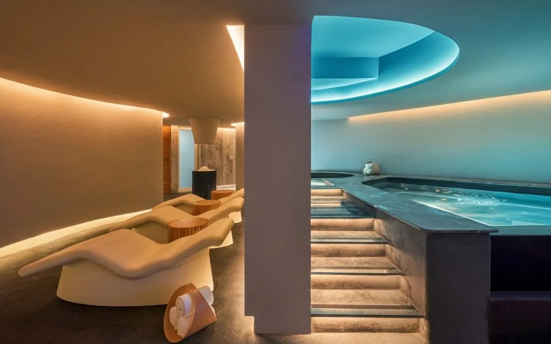 Spa lounge chairs sit beside illuminated indoor pools and steps at Viceroy Los Cabos.