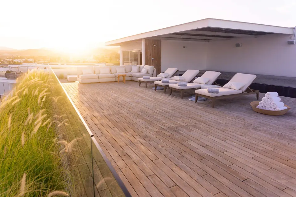 Penthouse rooftop terrace with loungers at sunset at Viceroy Los Cabos.