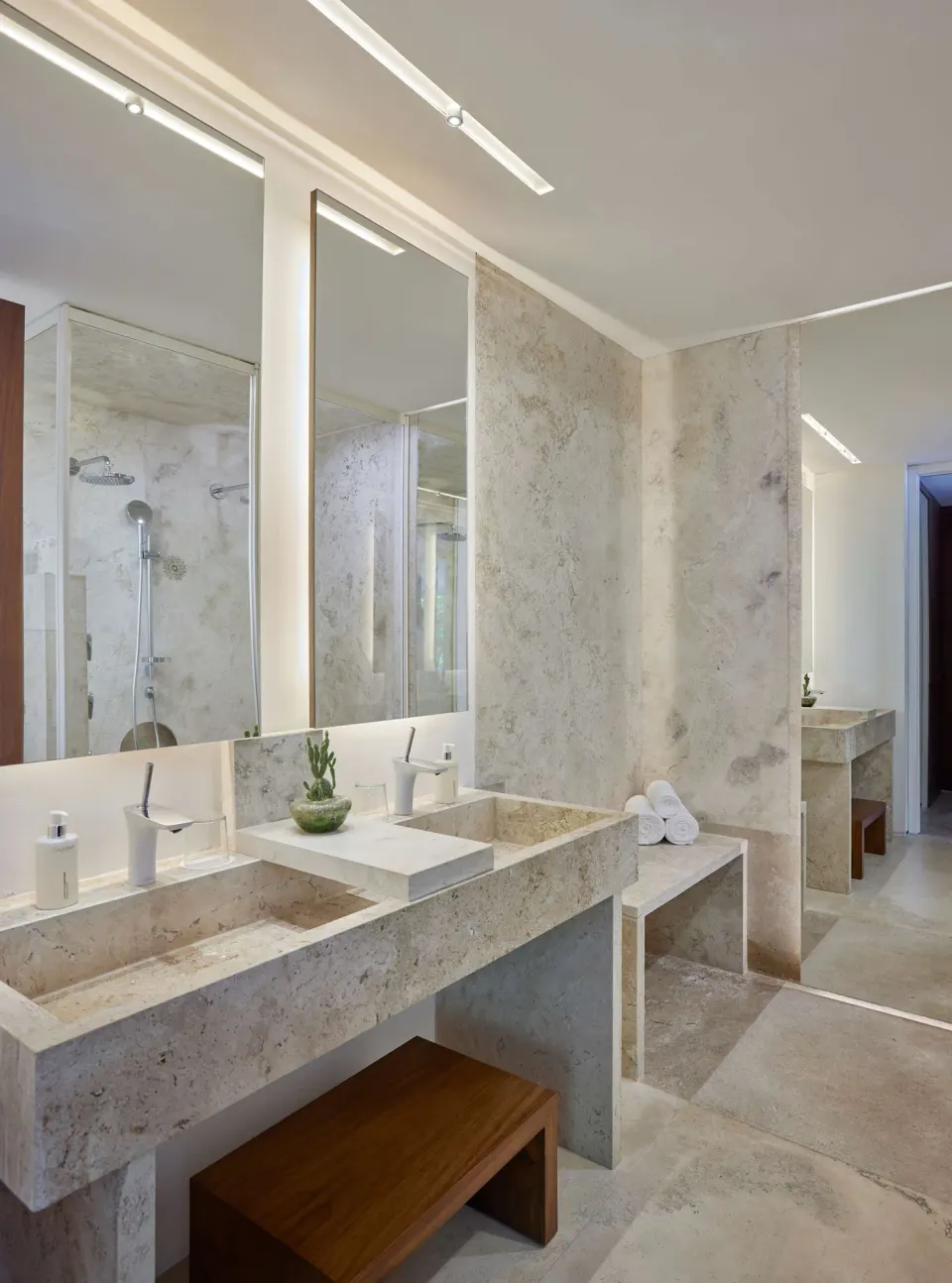 Stone bathroom vanity in a 3 Bedroom Waterside Casita at Viceroy Los Cabos with mirrors and shower.