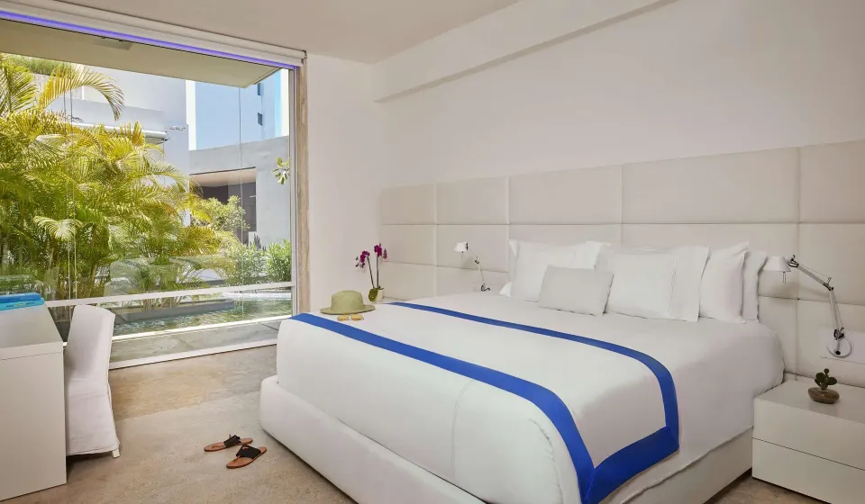 Bedroom in a 3 Bedroom Waterside Casita at Viceroy Los Cabos with a white bed and garden view.