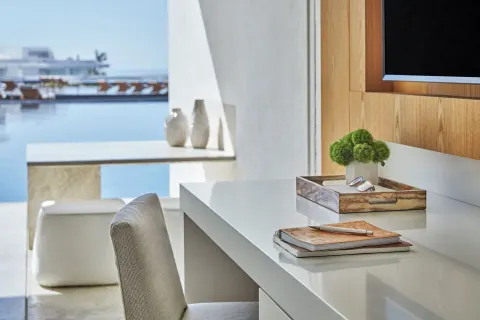 Desk, TV, and balcony water view in a Partial Ocean View room at Viceroy Los Cabos.