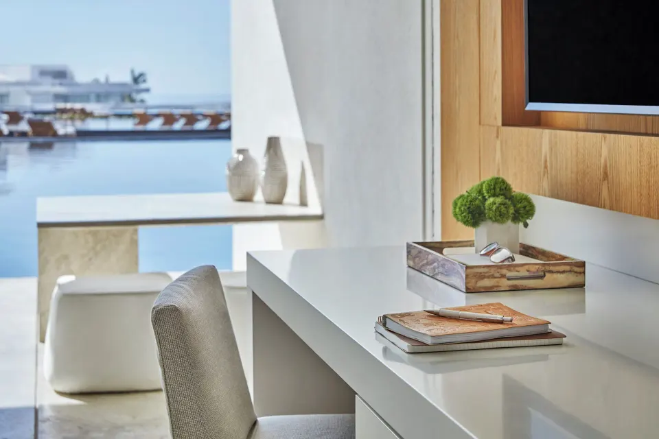 Desk, TV, and balcony water view in a Partial Ocean View room at Viceroy Los Cabos.