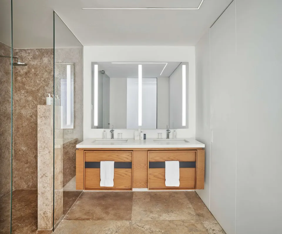 Partial Ocean View room bathroom with double vanity and glass shower at Viceroy Los Cabos.