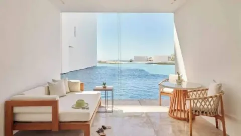 Private terrace seating beside blue water in a Partial Ocean View room at Viceroy Los Cabos.