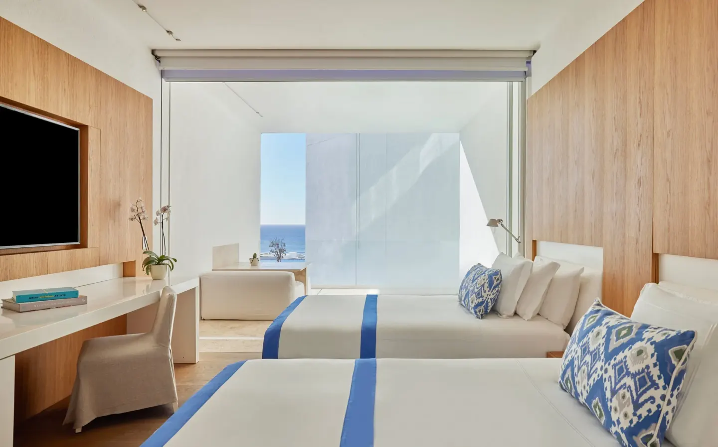 Two beds, desk, TV, and balcony view in a Partial Ocean View room at Viceroy Los Cabos.