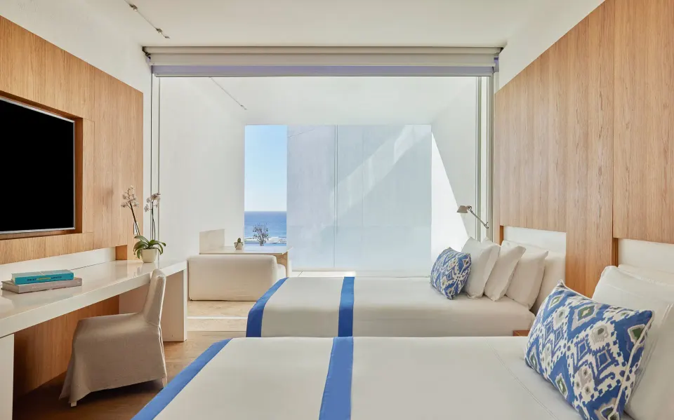 Two beds, desk, TV, and balcony view in a Partial Ocean View room at Viceroy Los Cabos.