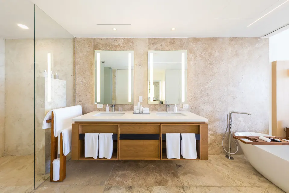 Suite bathroom with double vanity, glass shower, and soaking tub at Viceroy Los Cabos.