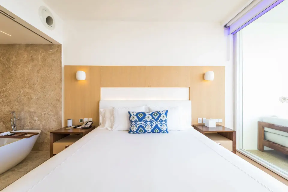 One Bedroom Partial Ocean View suite king bed beside glass doors at Viceroy Los Cabos.