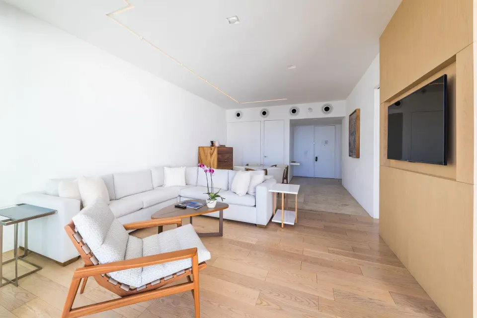 One-bedroom suite living room with sofa and TV at Viceroy Los Cabos.