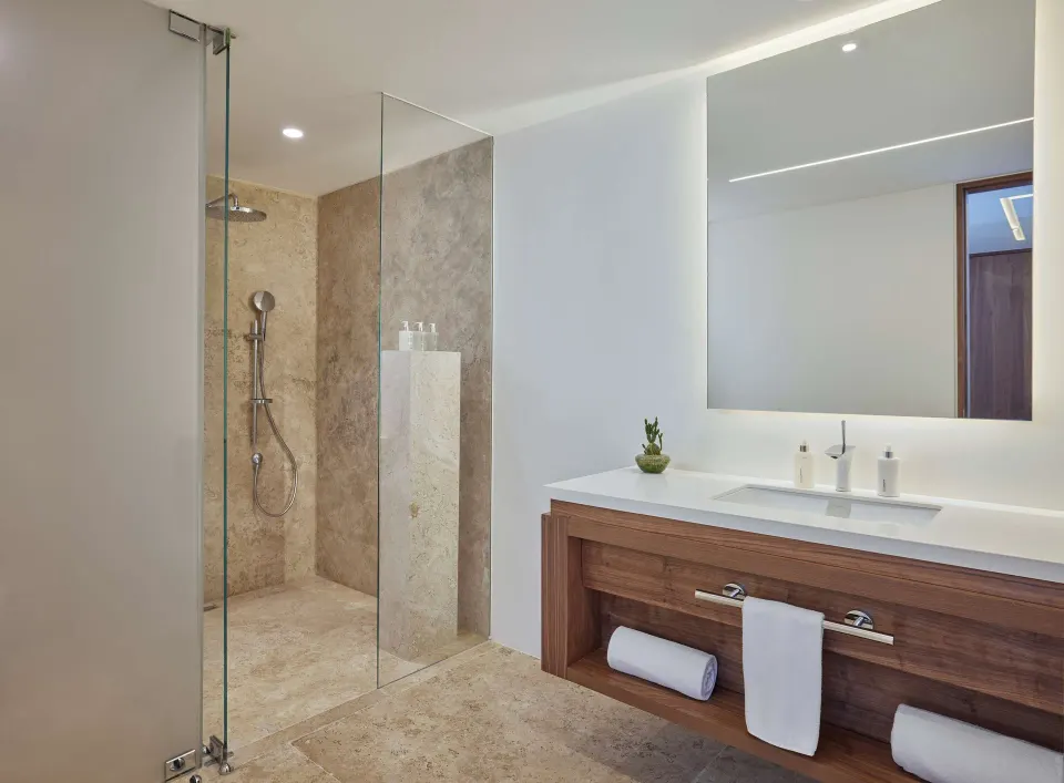 Ground-floor two-bedroom suite bathroom with glass shower and double vanity at Viceroy Los Cabos.