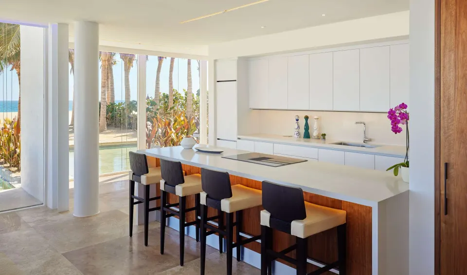 Suite kitchen island with bar stools and ocean-facing windows at Viceroy Los Cabos.