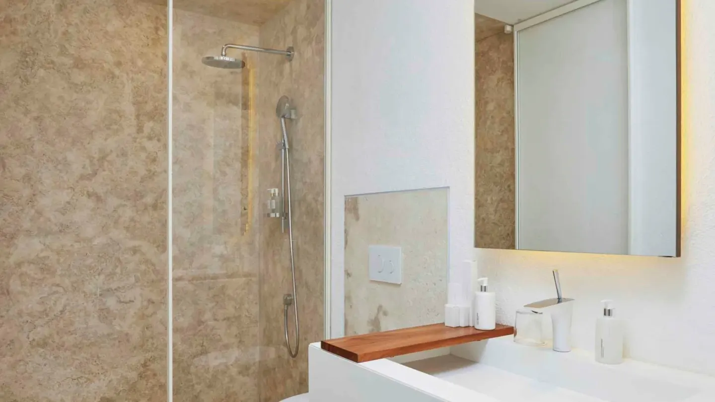Glass shower and white vanity in a two-bedroom ocean view suite bathroom at Viceroy Los Cabos.