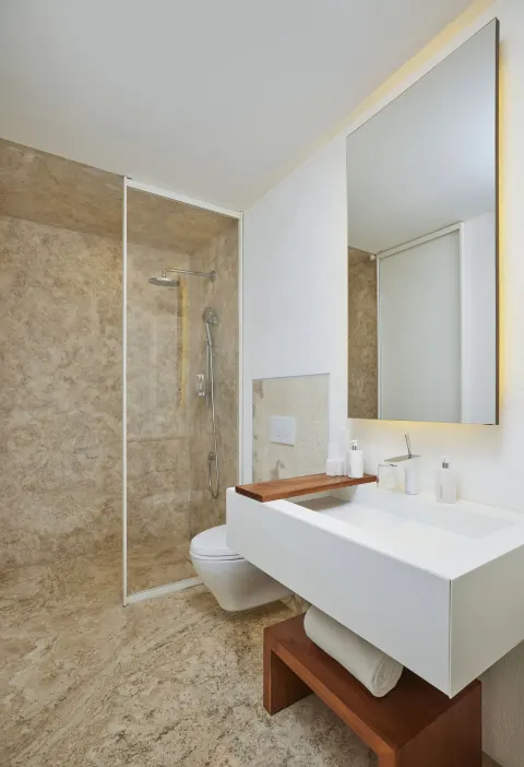 Suite bathroom with walk-in shower, vanity, and tall mirror at Viceroy Los Cabos.