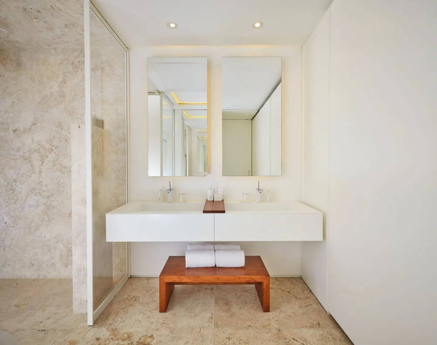 Double vanity bathroom with mirrors and stone shower wall at Viceroy Los Cabos.