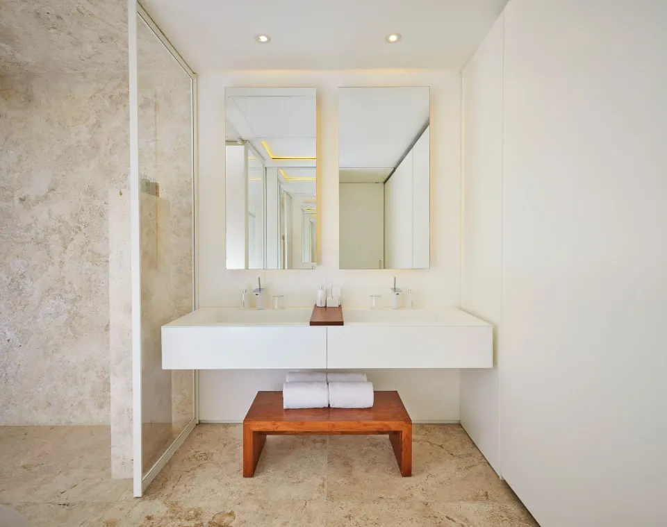 Double vanity bathroom with mirrors and stone shower wall at Viceroy Los Cabos.