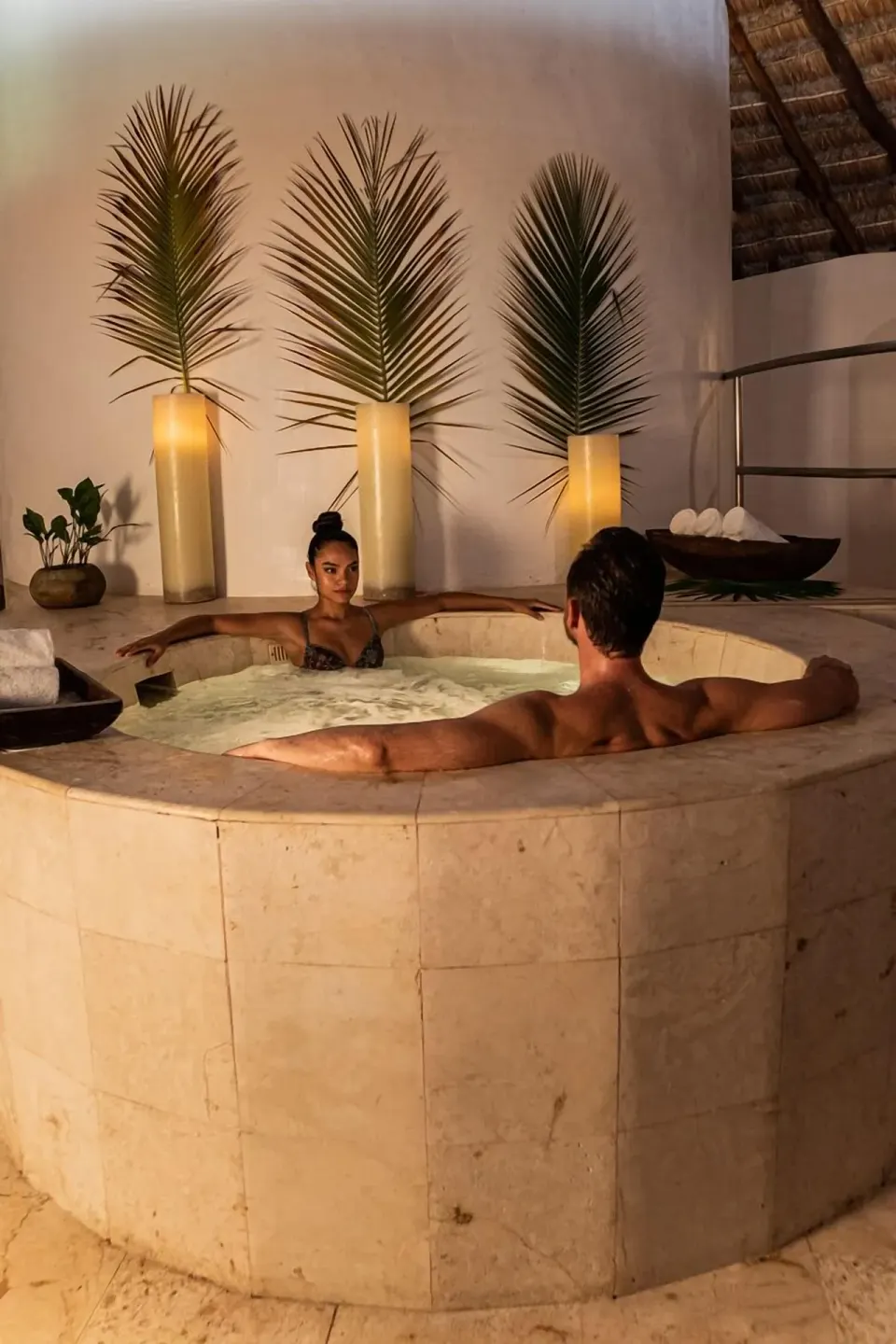 Couple in a circular stone spa tub at Viceroy Riviera Maya.